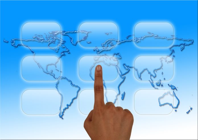 finger touching world on screen finger touching world on screen
