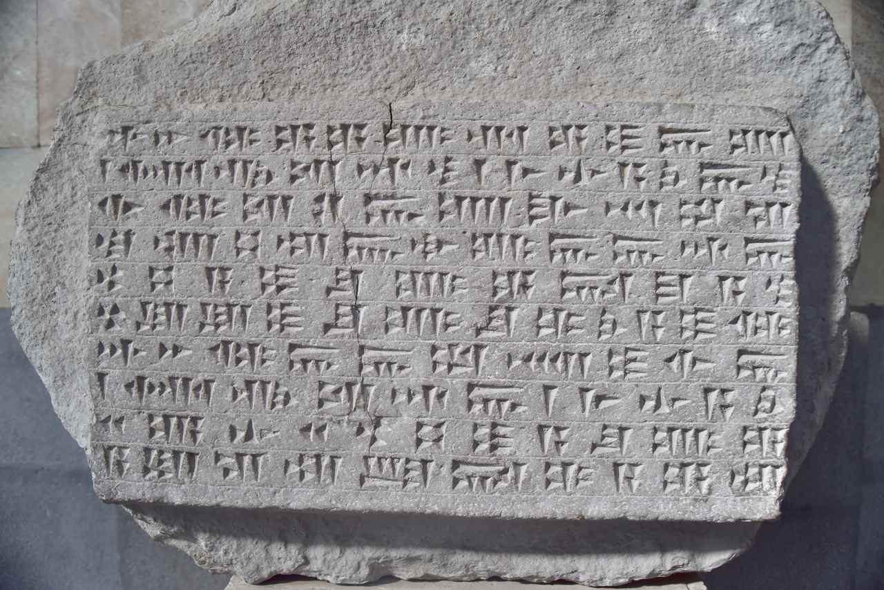 Ancient stone inscription, carved into a substantial slab of light‑grey volcanic stone.