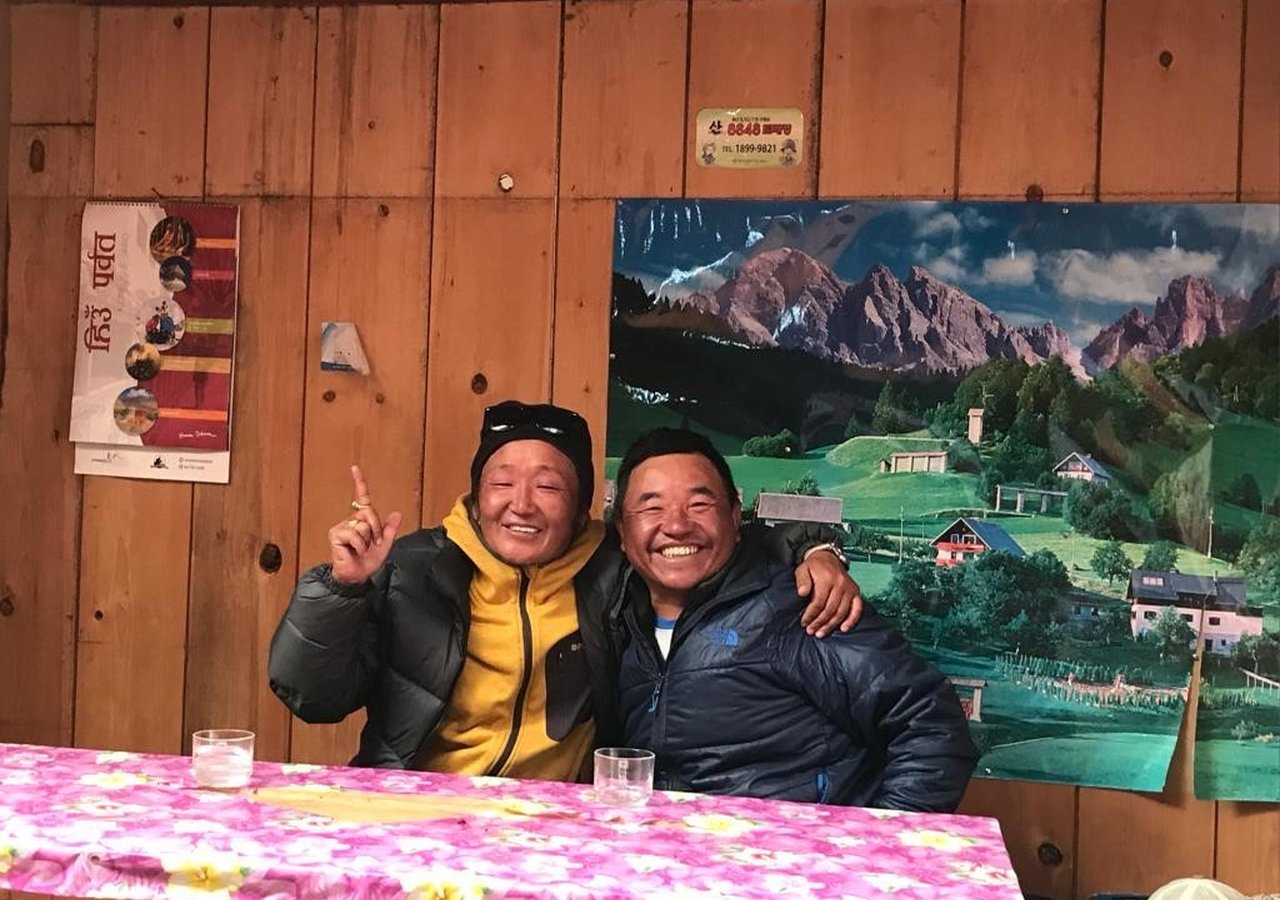 Bir misafirhanede yerel bir içeceğin tadını çıkaran iki yerel Sherpa rehberi. 