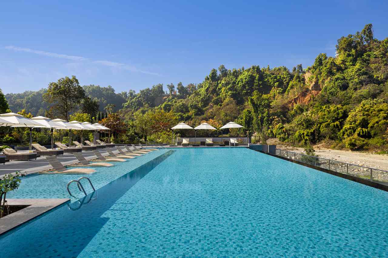The Swimming pool at the Le Meridien Dehradun along the river