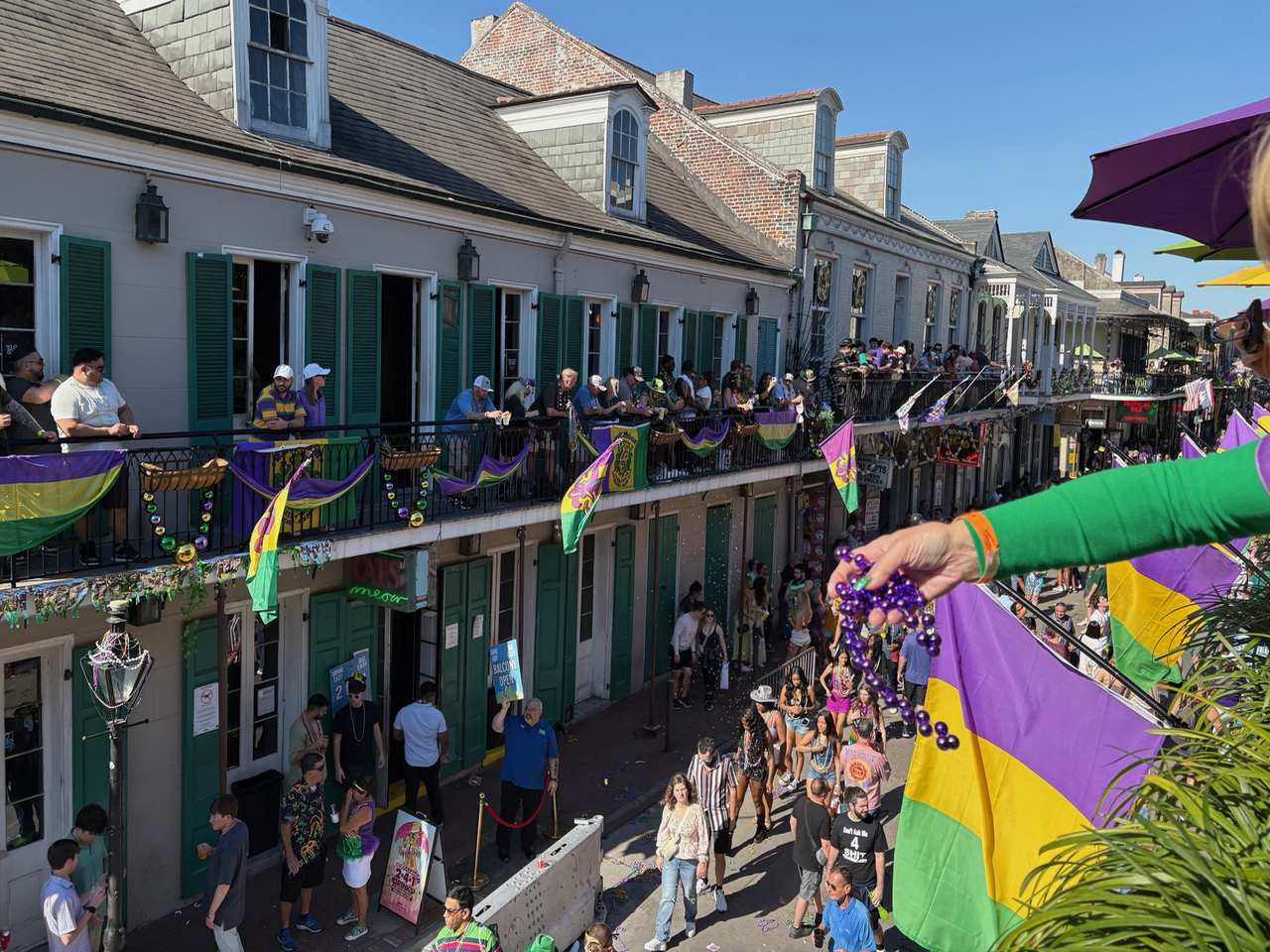 Throwing beads from the balcony in the French Quarter, Mardi Gras New Orleans